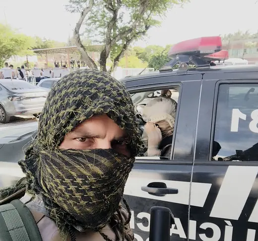 Diego em operação, ao lado da viatura da Polícia Civil