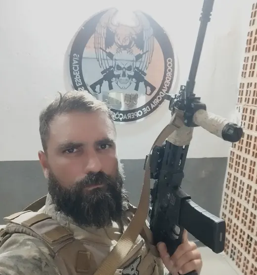 Diego diante do brasão da coordenadoria de operações especiais